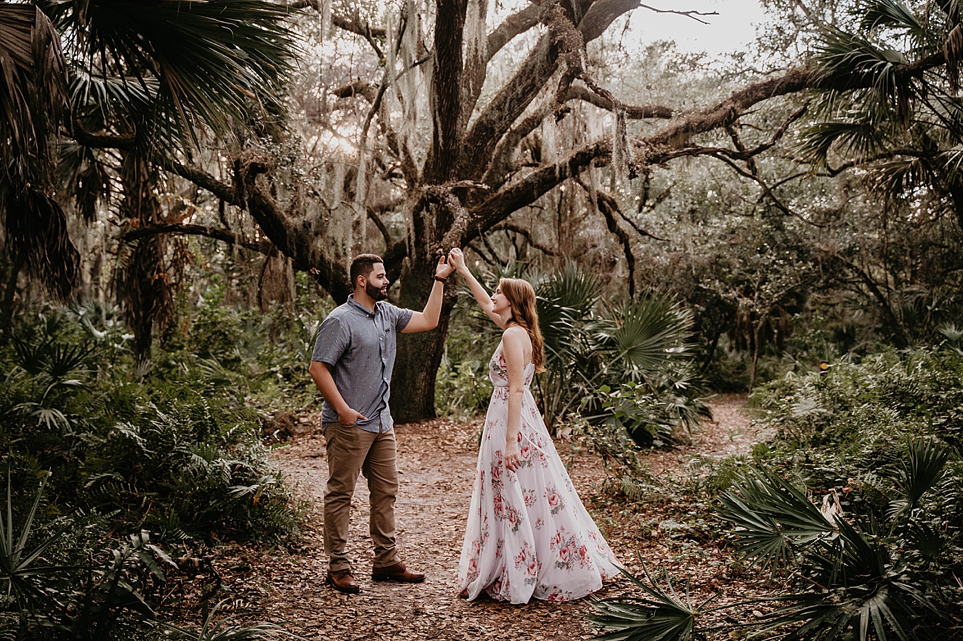 Couple pirouetting in the forest Delray Oaks Engagement Photography captured by South Florida Engagement Photographer Krystal Capone Photography 