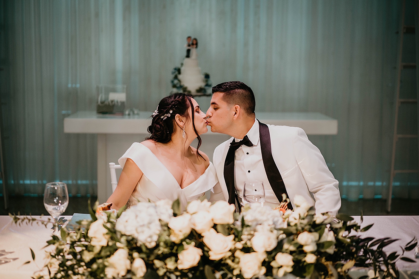 Bride and Groom kissing at sweetheart table Lavan Venue Wedding Photography captured by South Florida Wedding Photographer Krystal Capone Photography