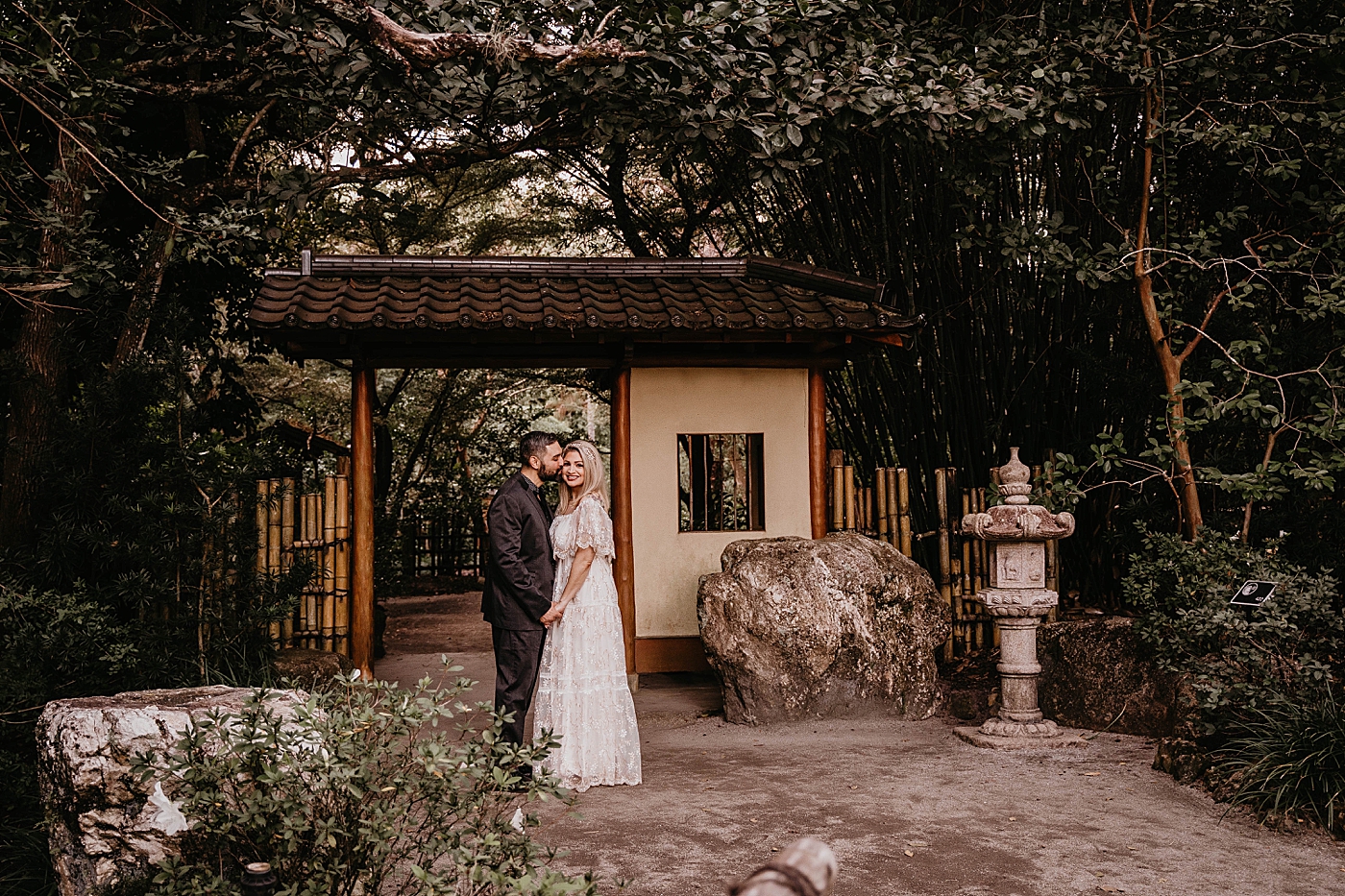 Couple close to each other posing in front of Japanese Garden Scenery Morikami Museum and Japanese Gardens Engagement Photography captured by Krystal Capone Photography