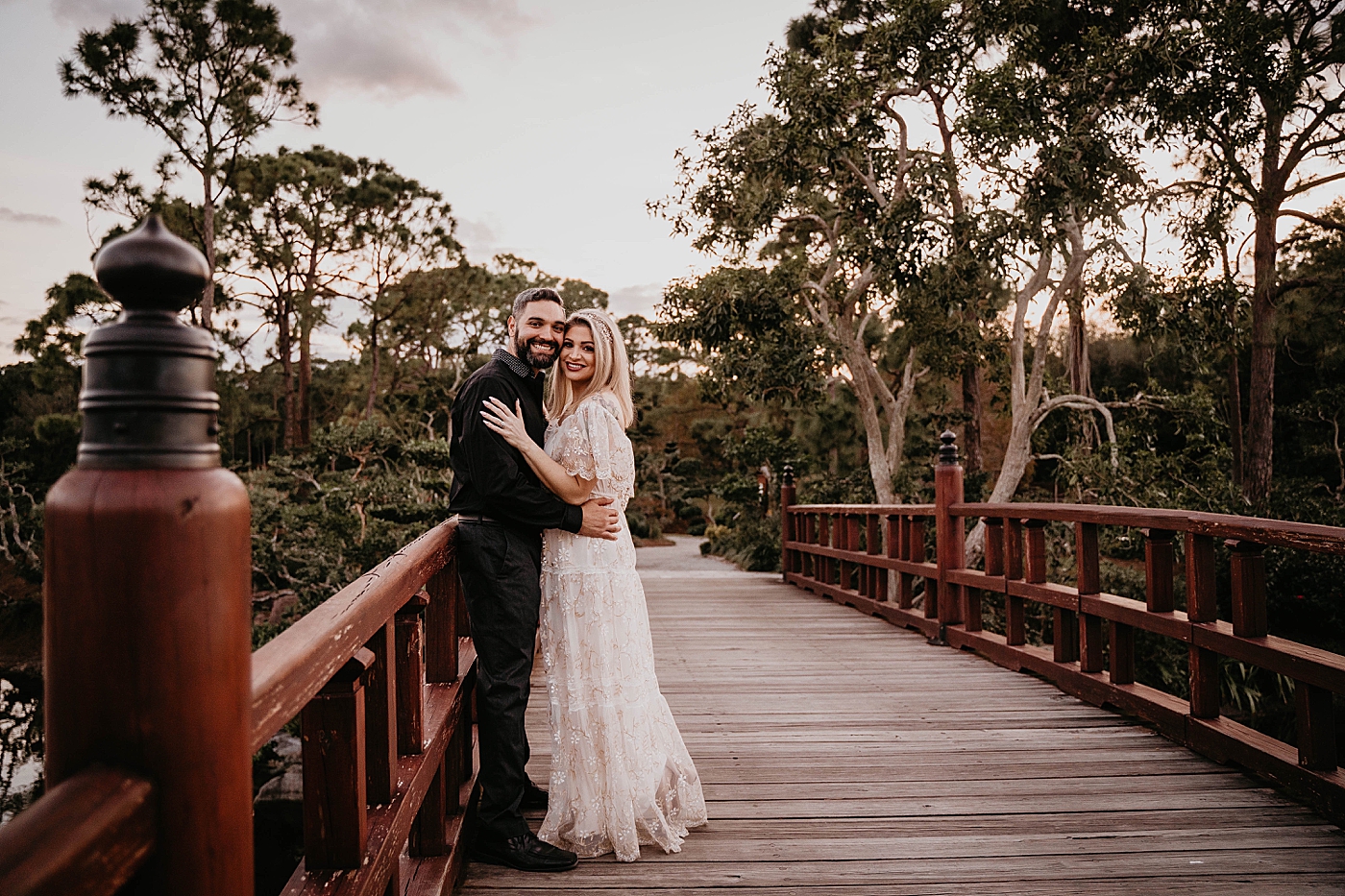 Couple posing on Japanese inspired bridge Morikami Museum and Japanese Gardens Engagement Photography captured by Krystal Capone Photography