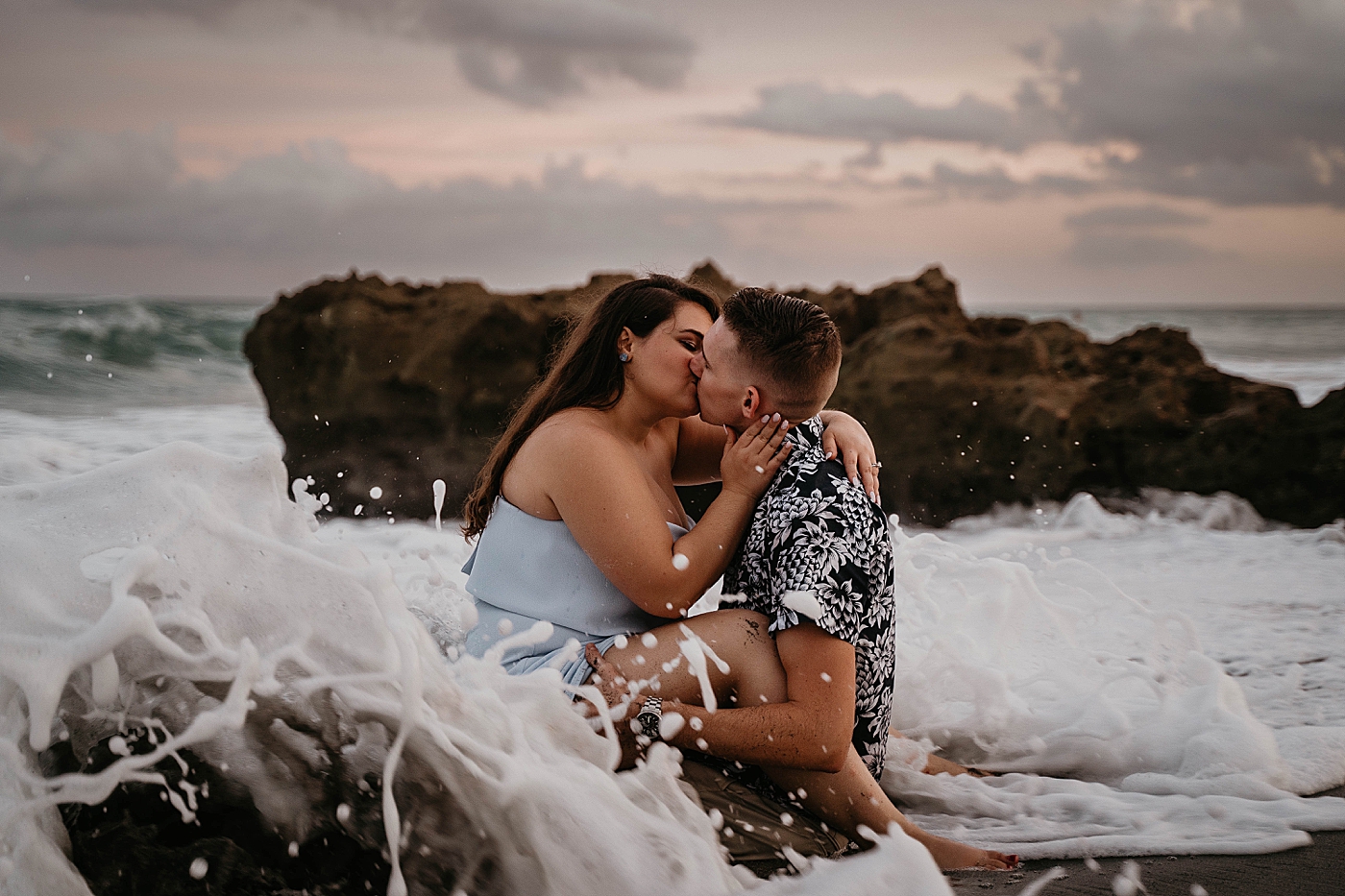 Couple kissing each other while waves crash on them South Florida Beach Photography captured by Krystal Capone Photography