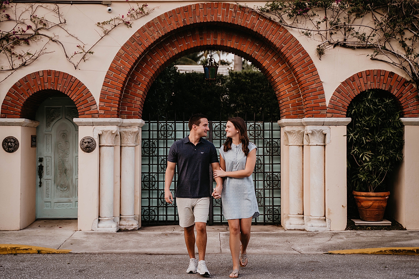 Couple walking in front of arch entrance Palm Beach Engagement Photography captured by South Florida Engagement Photographer Krystal Capone Photography