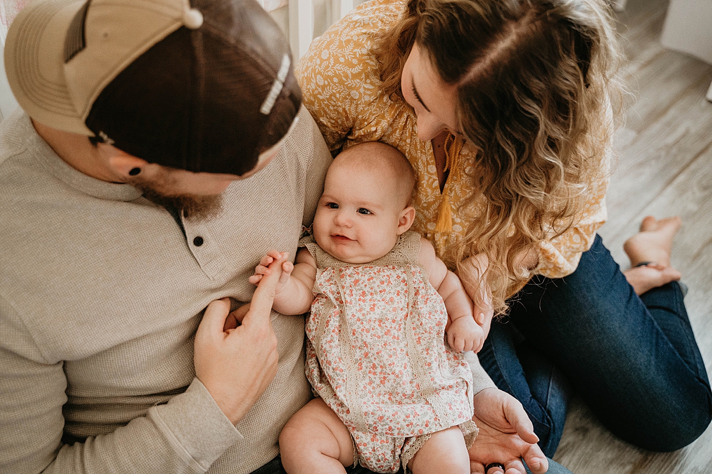 Baby holding Dad's pointer finger on his lap At Home South Florida Family Photography captured by South Florida Family Photographer Krystal Capone Photography 