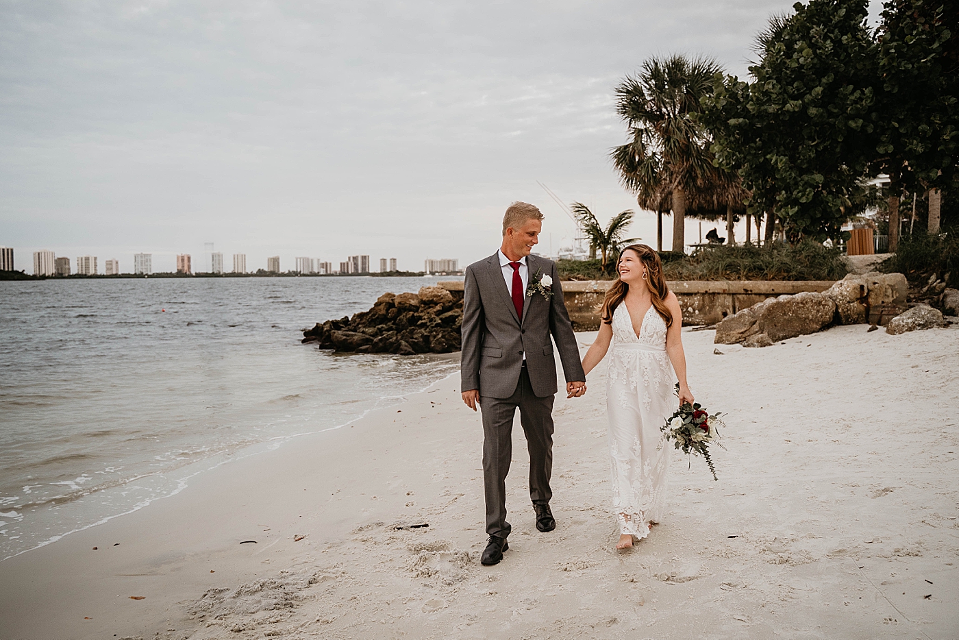 Bride and Groom walking on the beach South Florida Elopement Photography captured by Krystal Capone Photography