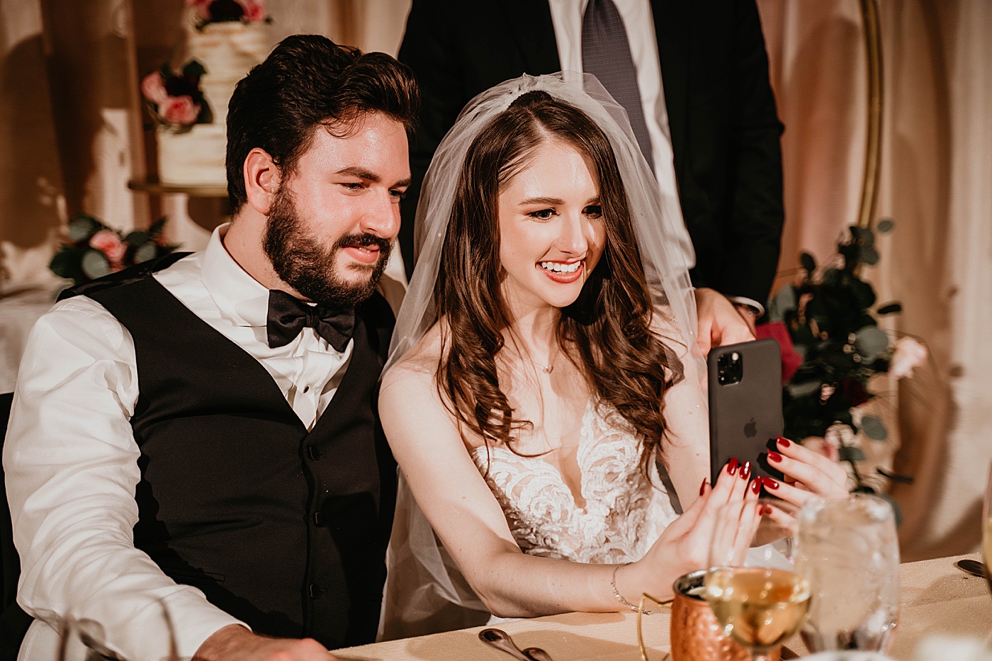 Bride and Groom facetiming family at reception Breakers West Wedding Photography captured by South Florida Wedding Photographer Krystal Capone Photography 