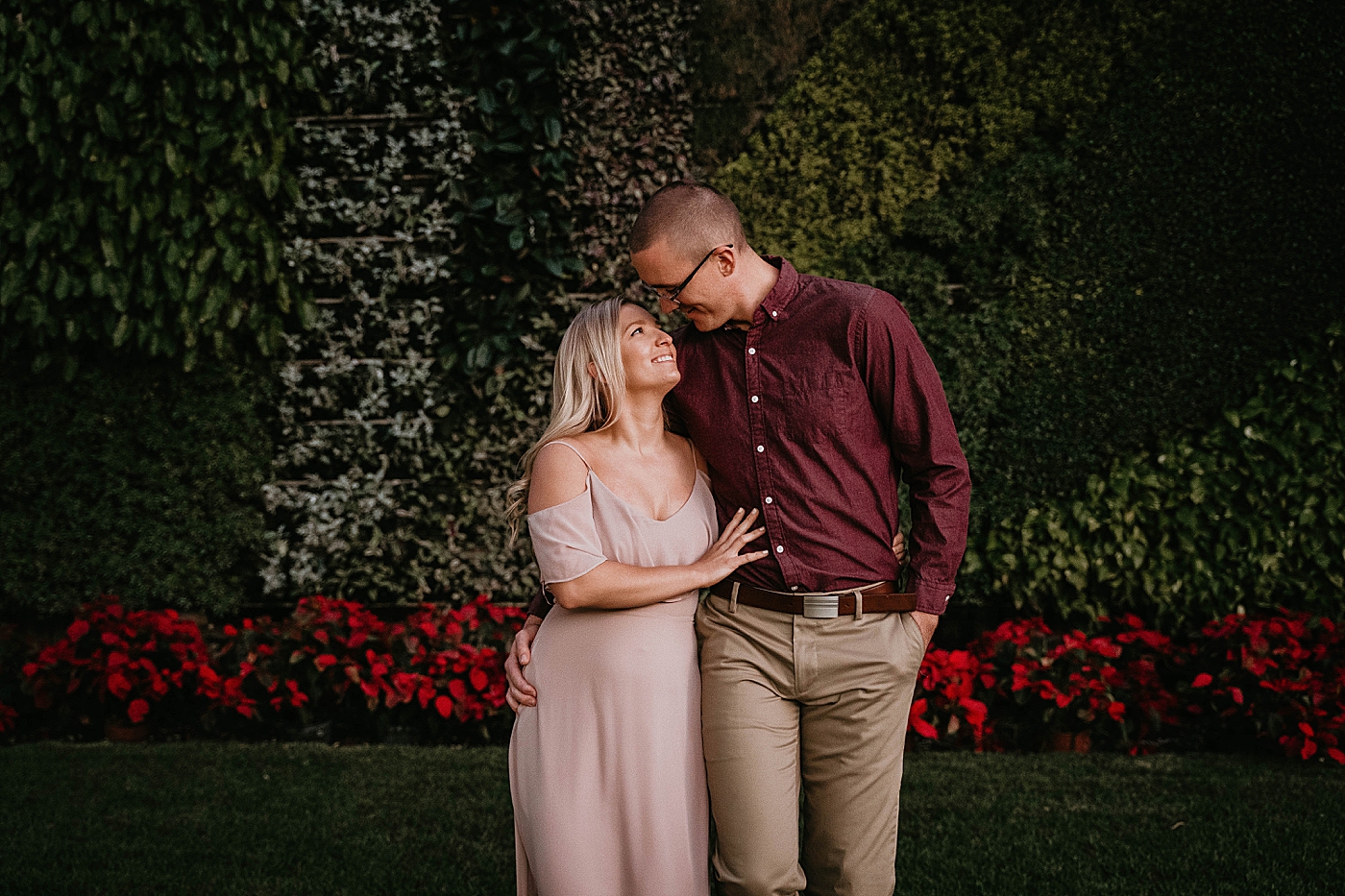 Couple holding each other with red flowers Worth Ave Engagement Photography captured by Engagement Photographer Krystal Capone Photography