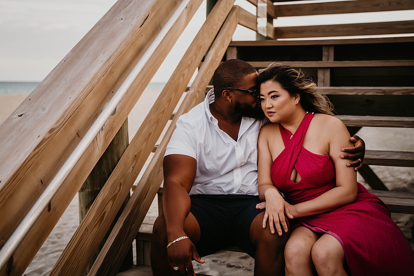 Husband nuzzling wife on beach staircase Palm Beach Anniversary Photography captured by South Florida Family Photographer Krystal Capone Photography