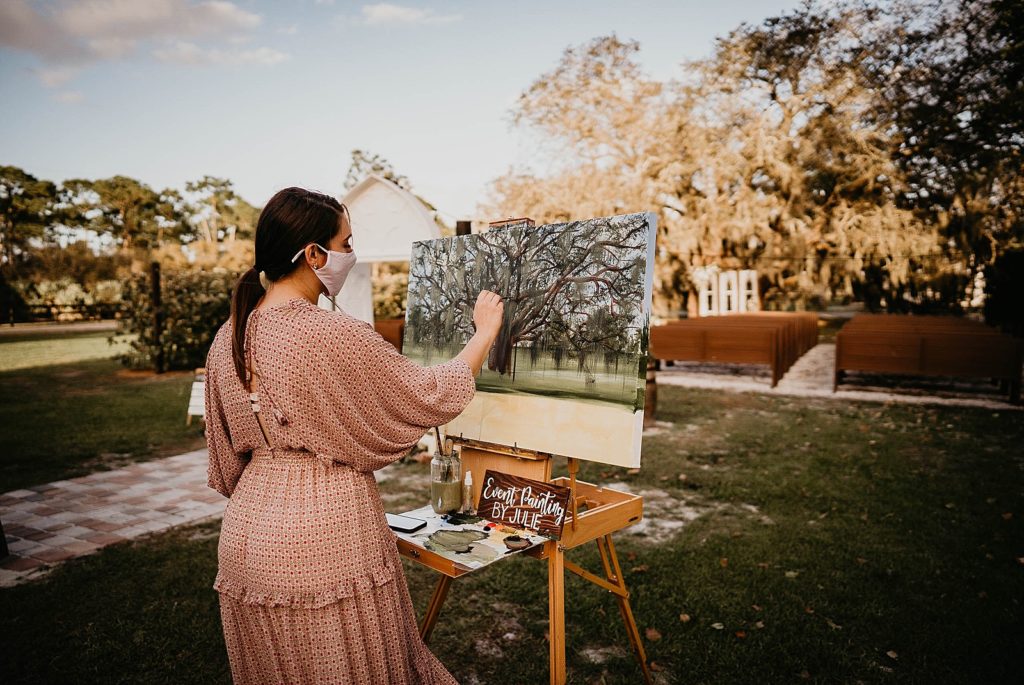 Painter with mask on painting Ceremony area Ever After Farms Wedding Photography captured by South Florida Wedding Photographer Krystal Capone Photography 