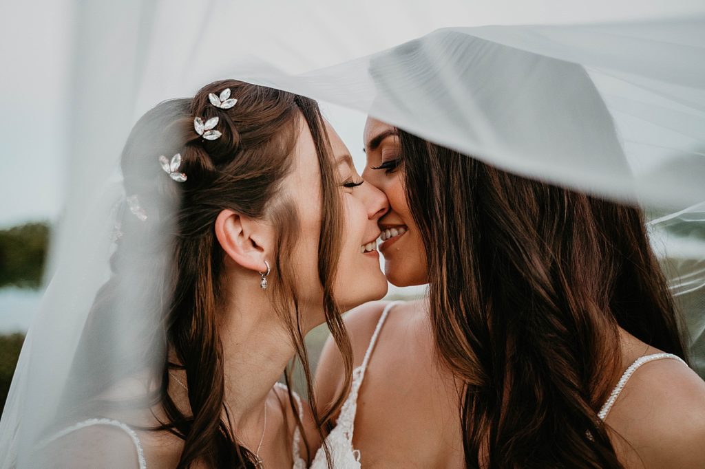 Brides about to kiss under the veil LGBTQIA+ Hawks Cay Resort Wedding Photography captured by South Florida Wedding Photographer Krystal Capone Photography 