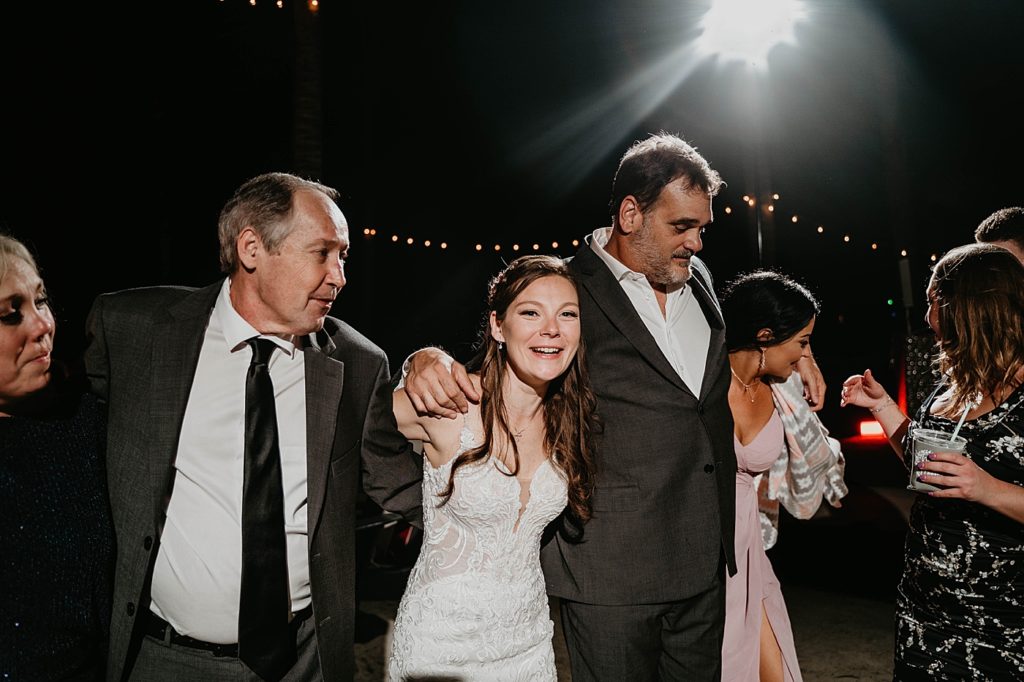 Bride arm in arm with attendees for dance at Reception Hawks Cay Resort Wedding Photography captured by South Florida Wedding Photographer Krystal Capone Photography