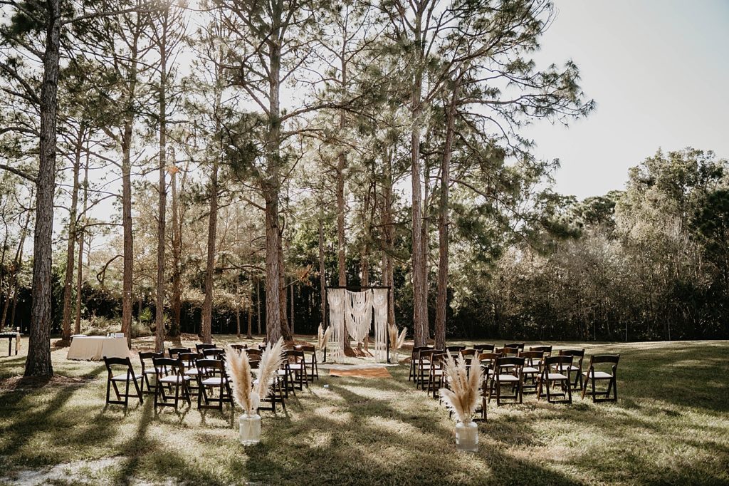 Ceremony Detail Shot of Back folding chairs and white archway outdoors Intimate South Florida Wedding Photography captured by South Florida Wedding Photographer Krystal Capone Photography