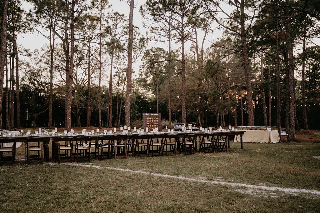 Outdoor Reception detail shot of long single table with candles in forest Intimate South Florida Wedding Photography captured by South Florida Wedding Photographer Krystal Capone Photography
