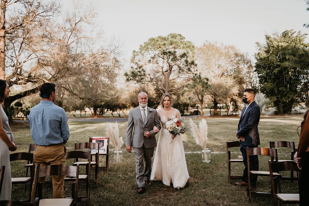 Father and Bride arm in arm entering Ceremony with attendees standing Intimate South Florida Wedding Photography captured by South Florida Wedding Photographer Krystal Capone Photography
