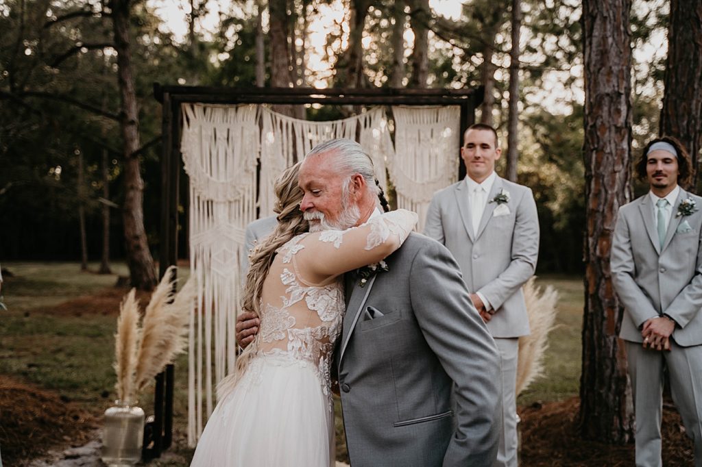 Bride hugging Father with Groom standing Ceremony Intimate South Florida Wedding Photography captured by South Florida Wedding Photographer Krystal Capone Photography