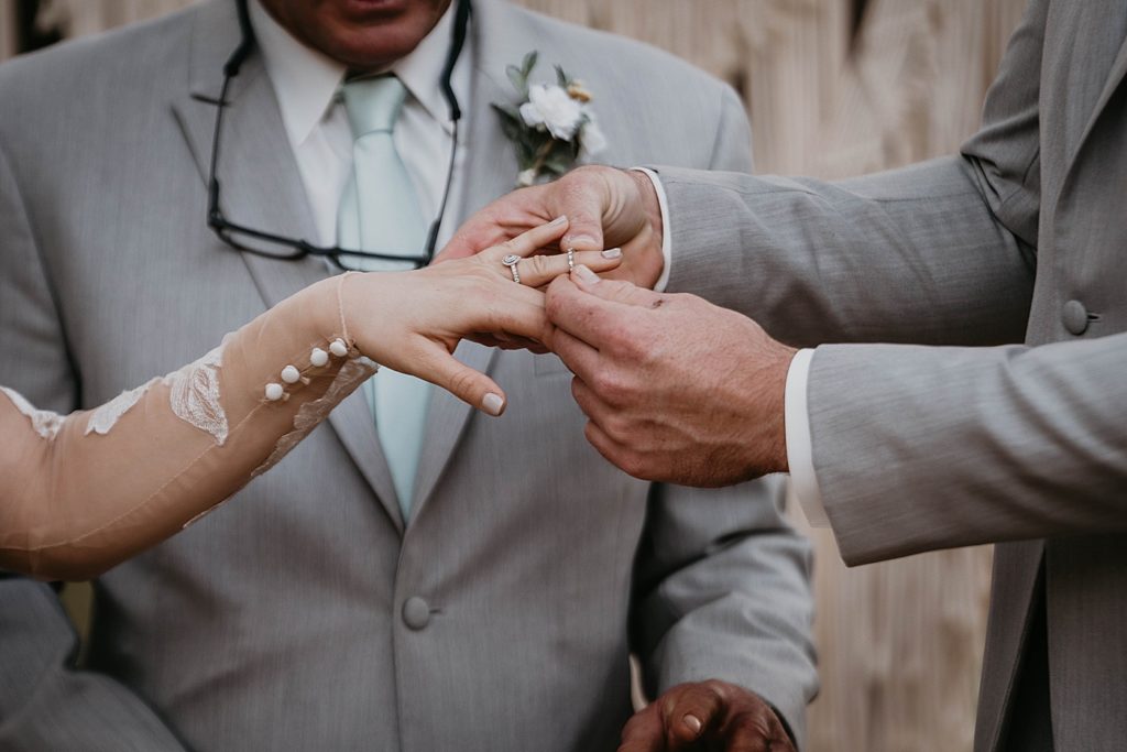 Closeup of Groom putting ring on Bride Outdoor Ceremony Intimate South Florida Wedding Photography captured by South Florida Wedding Photographer Krystal Capone Photography