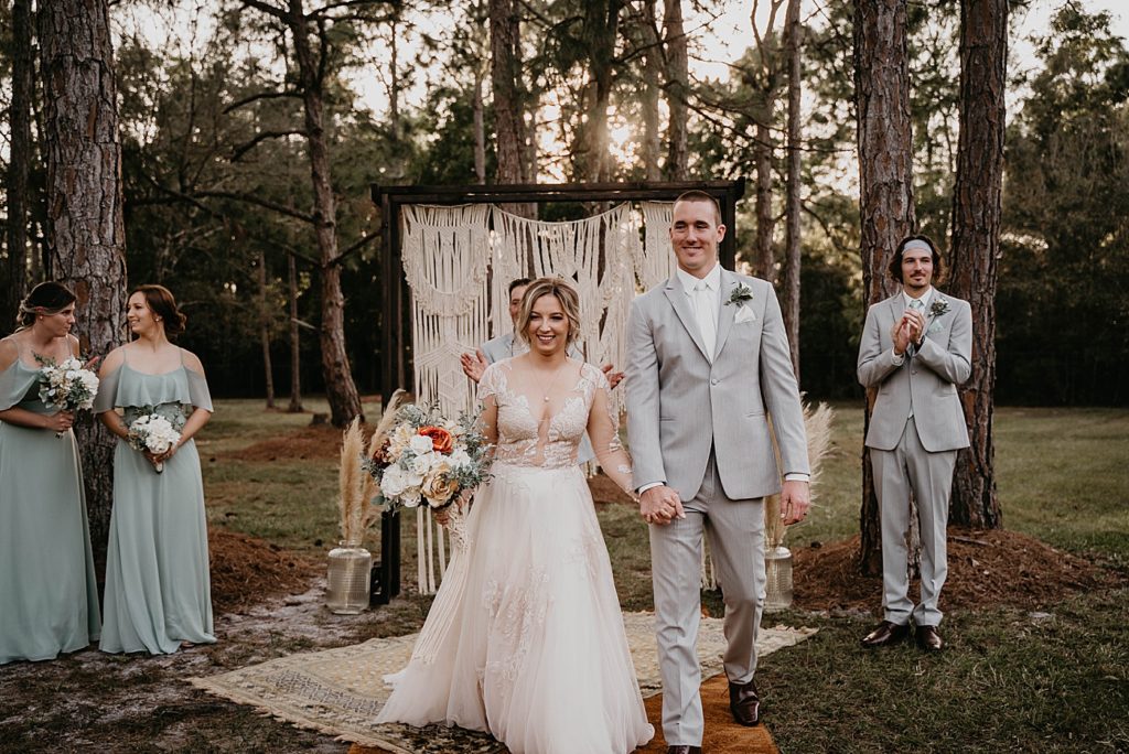 Bride and Groom holding hands exiting Outdoor Ceremony Intimate South Florida Wedding Photography captured by South Florida Wedding Photographer Krystal Capone Photography