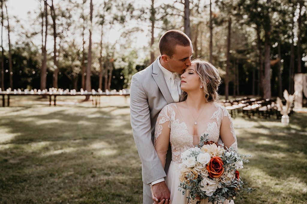 Groom kissing Bride on forehead outside in the forest Intimate South Florida Wedding Photography captured by South Florida Wedding Photographer Krystal Capone Photography