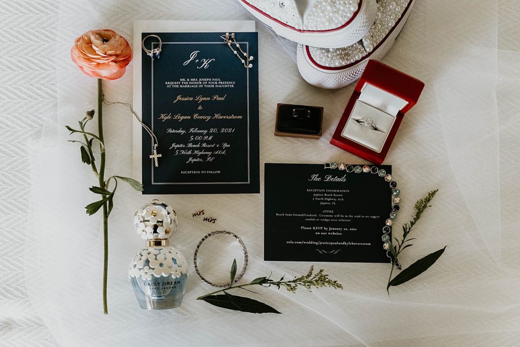 Wedding detail shot of save the date invitation pearly shoe wedding bands and engagement ring and perfume Jupiter Beach Resort Wedding Photography captured by South Florida Wedding Photographer Krystal Capone Photography 