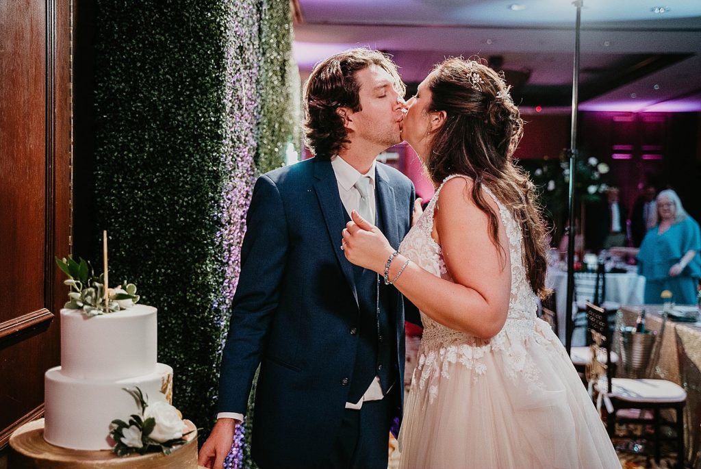 Bride and Groom kissing after cake cutting and tasting Jupiter Beach Resort Wedding Photography captured by South Florida Wedding Photographer Krystal Capone Photography 