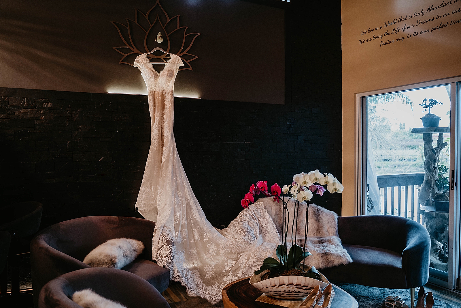 Wedding detail shot of wedding dress hanging in dim lit room Living Sculptures Sanctuary Wedding Photography captured by South Florida Wedding Photographer Krystal Capone Photography