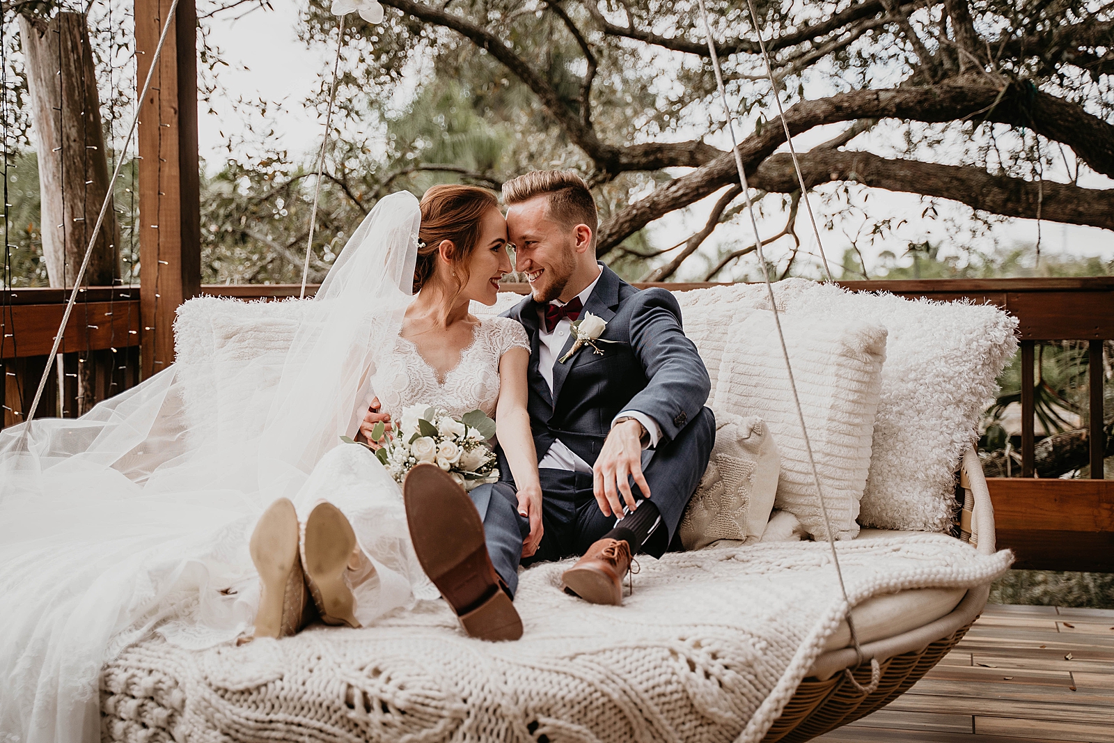 Bride and Groom sitting on swinging bed touching their foreheads together Living Sculptures Sanctuary Wedding Photography captured by South Florida Wedding Photographer Krystal Capone Photography