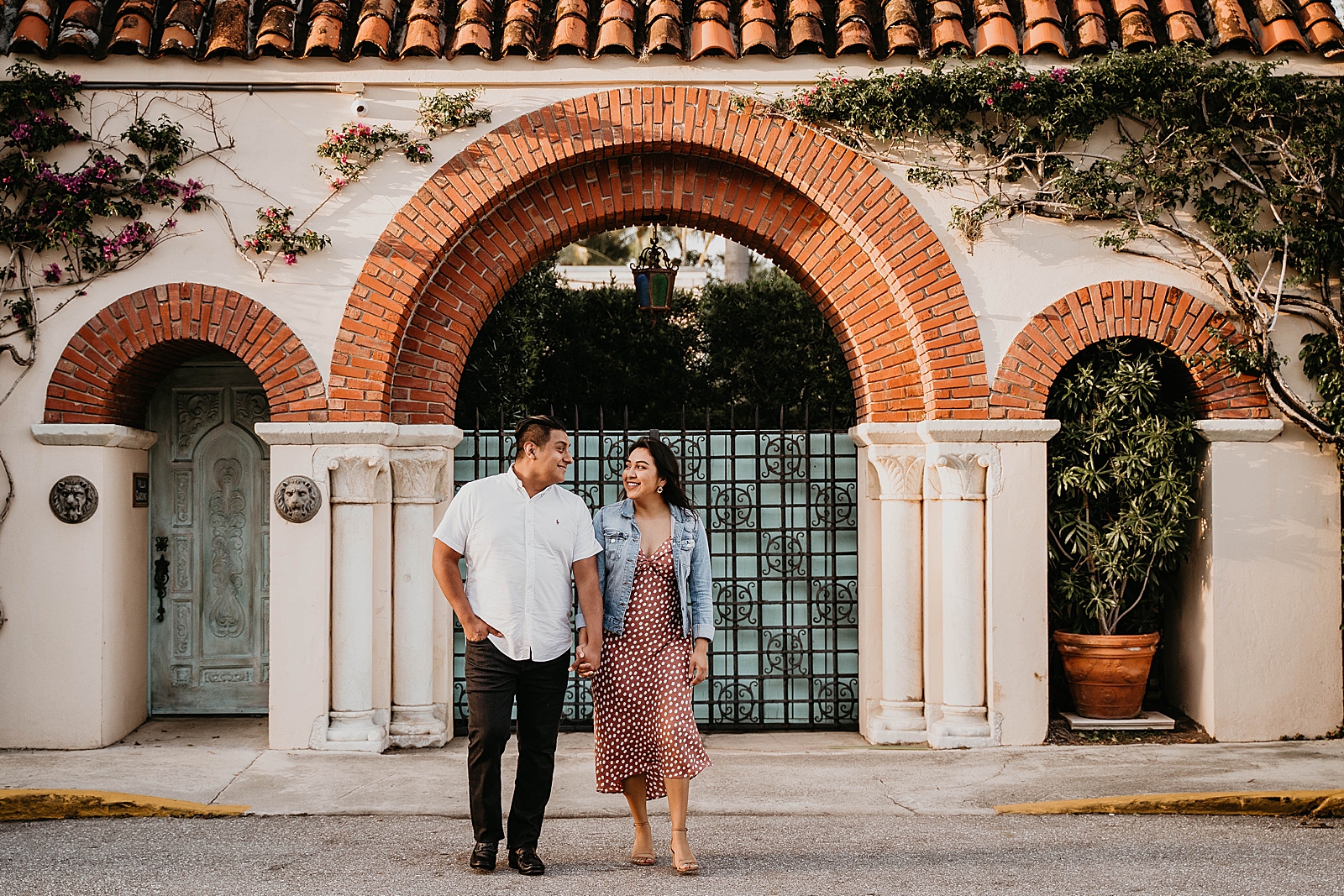 Couple holding hands looking at each other crossing the street Palm Beach Island Engagement Photography captured by South Florida Engagement Photographer Krystal Capone Photography 