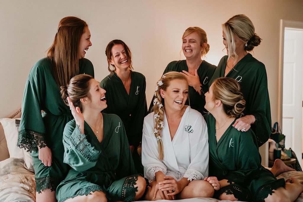 Bride and Bridesmaids laughing before getting ready in robes The Lake House Fort Pierce Wedding Photography captured by South Florida Wedding Photographer Krystal Capone Photography 