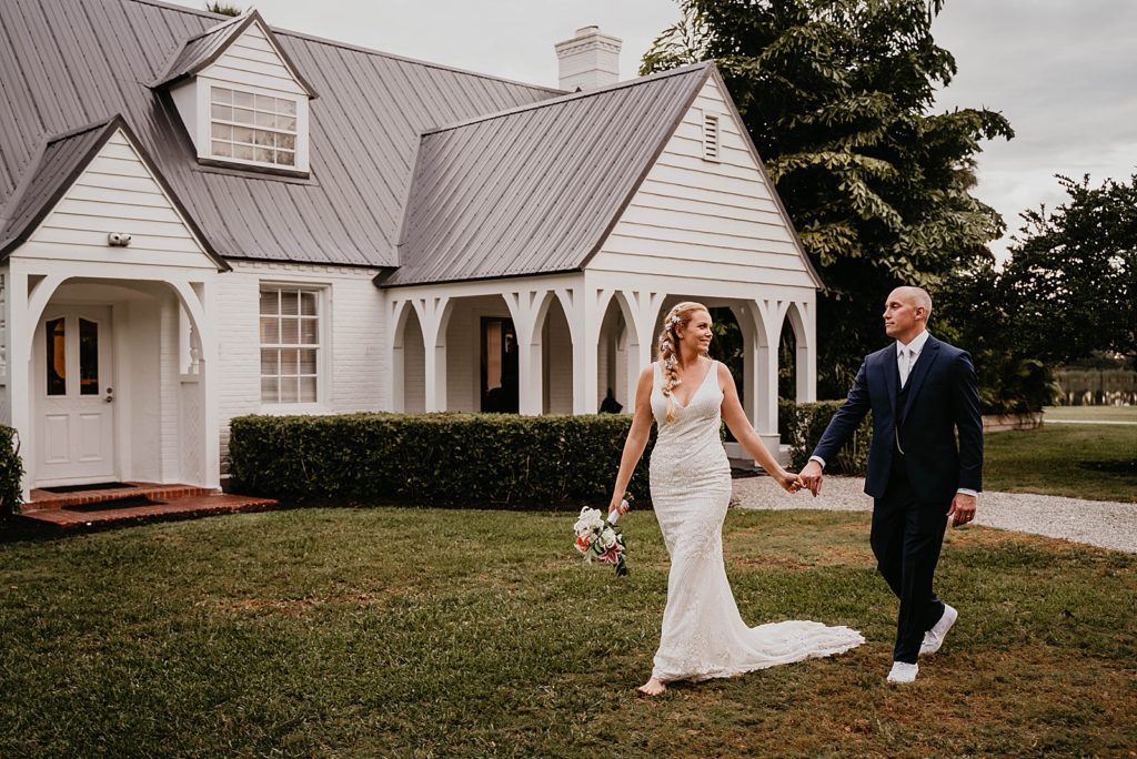 Bride leading Groom holding his hand across grass The Lake House Fort Pierce Wedding Photography captured by South Florida Wedding Photographer Krystal Capone Photography 