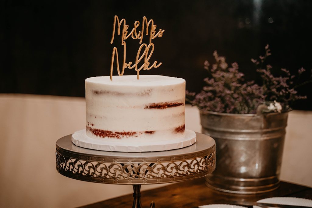 Single tier wedding cake with Mr and Mrs last name cake topper The Lake House Fort Pierce Wedding Photography captured by South Florida Wedding Photographer Krystal Capone Photography 