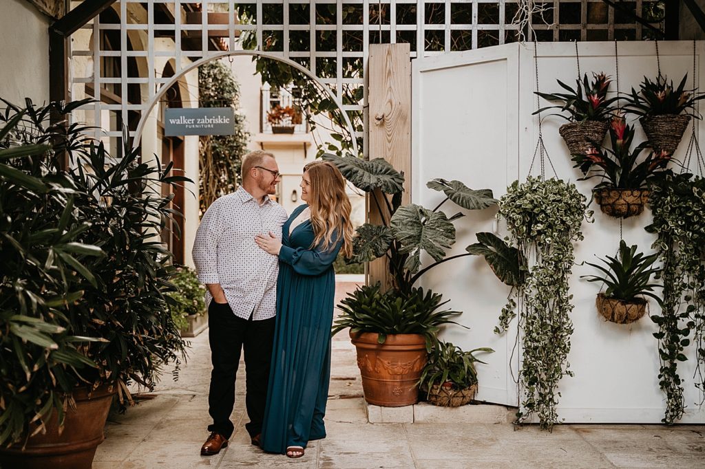 Couple holding and looking at each other in botanical garden area Worth Ave Palm Beach Engagement Photography captured by South Florida Engagement Photographer Krystal Capone Photography