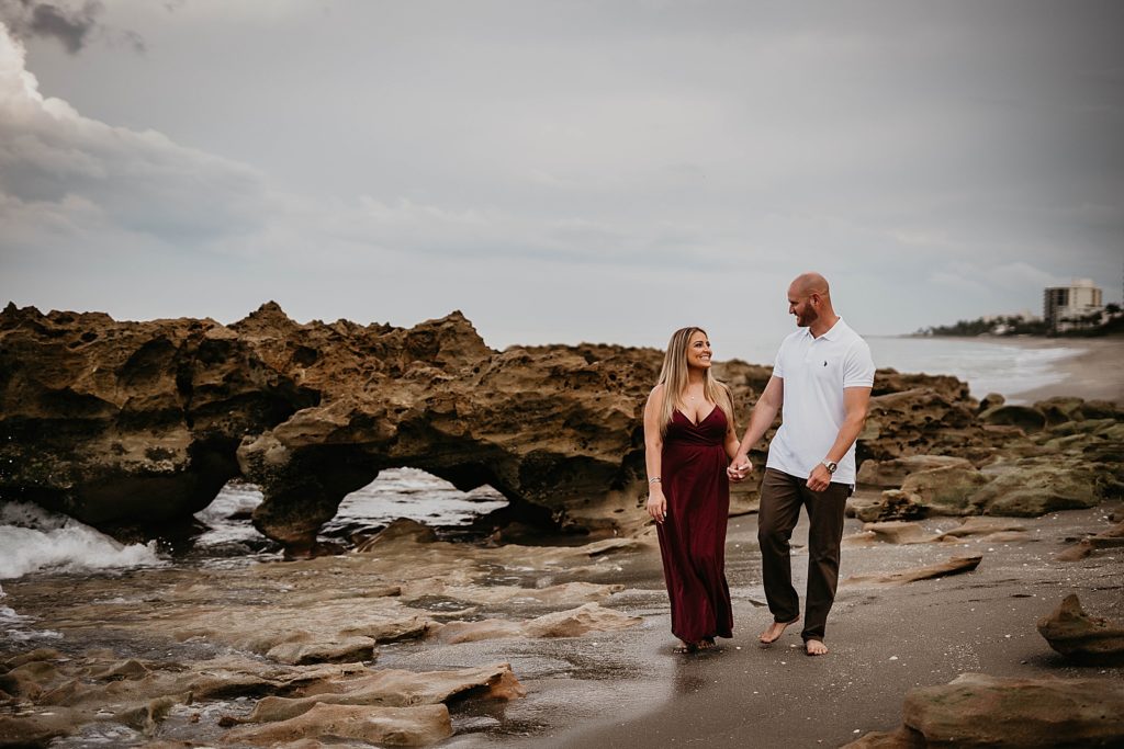 Couple holding hands and walking on the beach