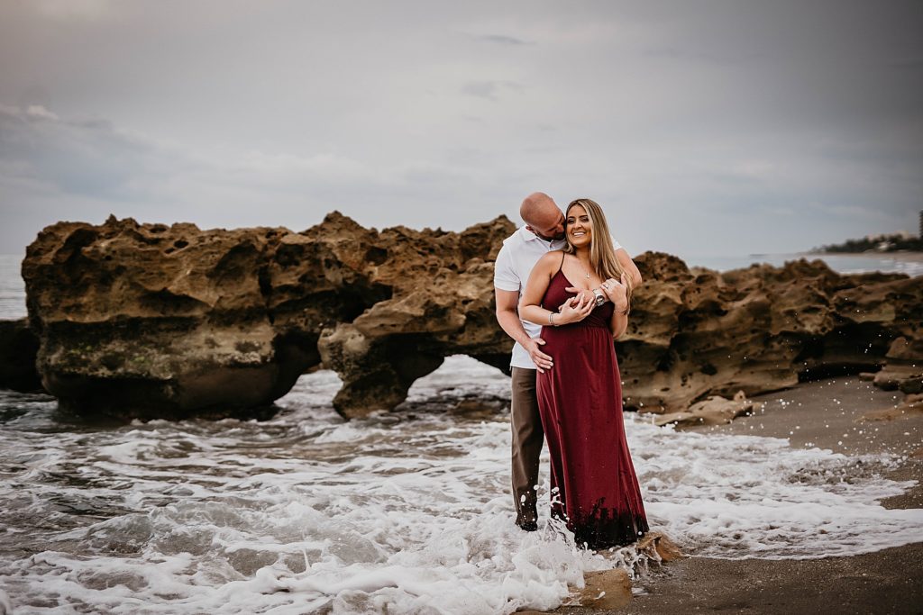 Man holding lady in shallow ocean water