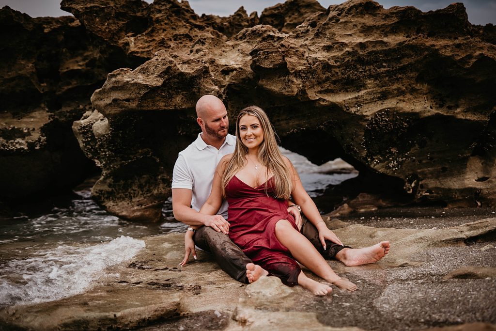 Couple sitting on the beach by the beach rock on the beach