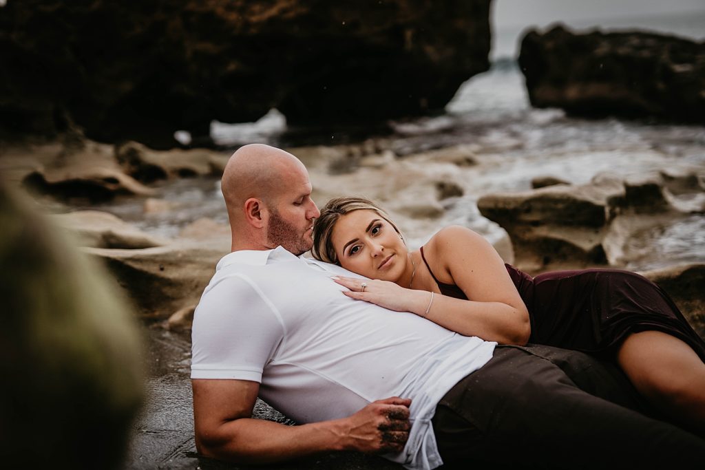 Couple laying on the wet sand together