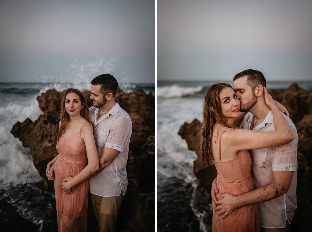 Couple posing by drift rock on the beach
