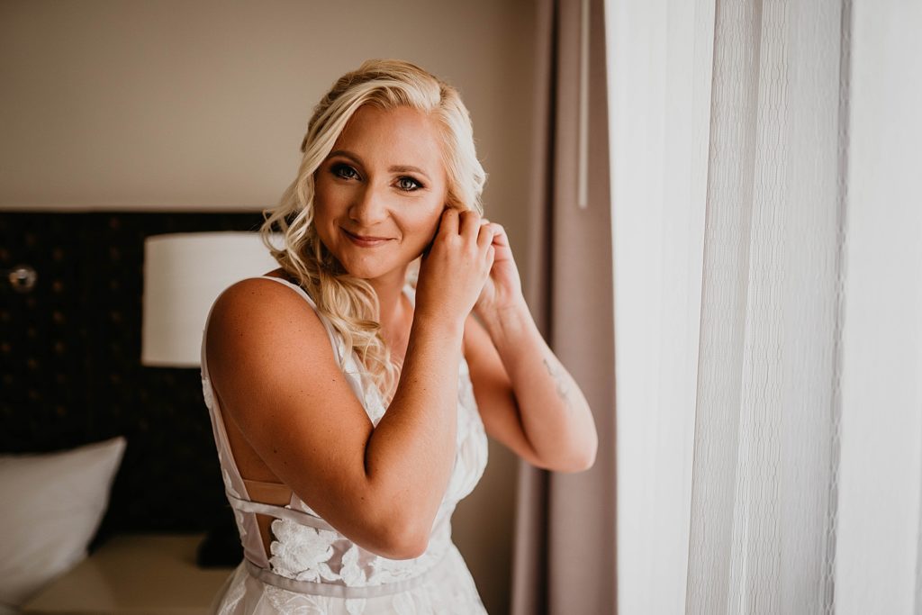 Bride putting earrings on getting ready