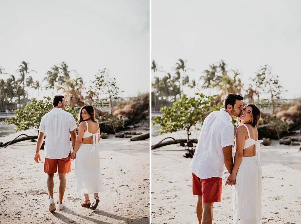 Couple walking on the sand with the palm trees in the distance
