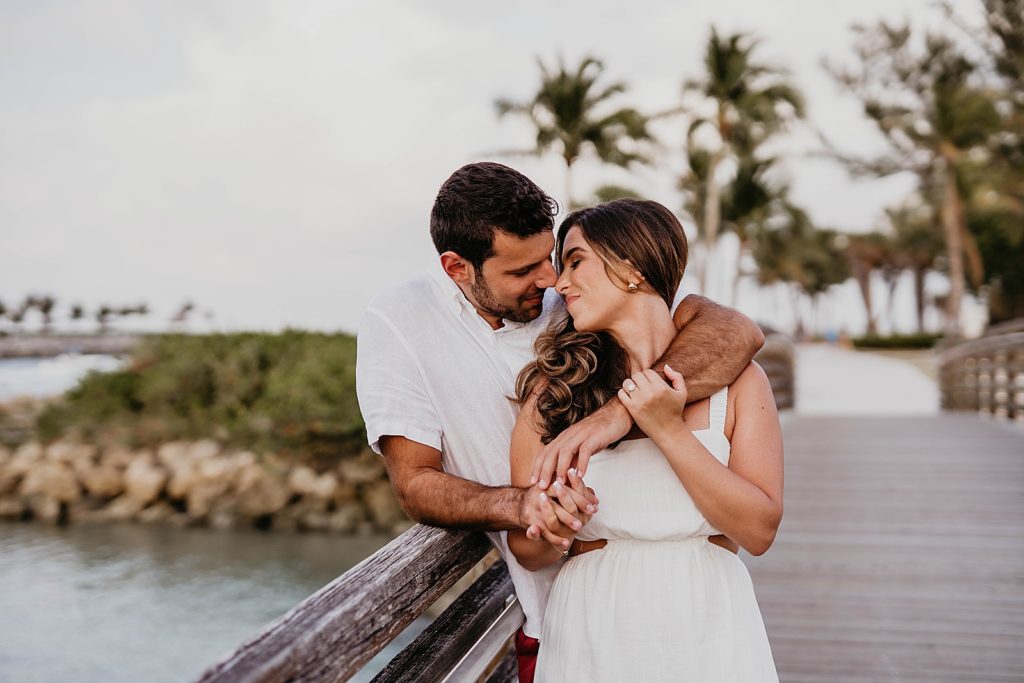 Couple nuzzling their noses on the bridge