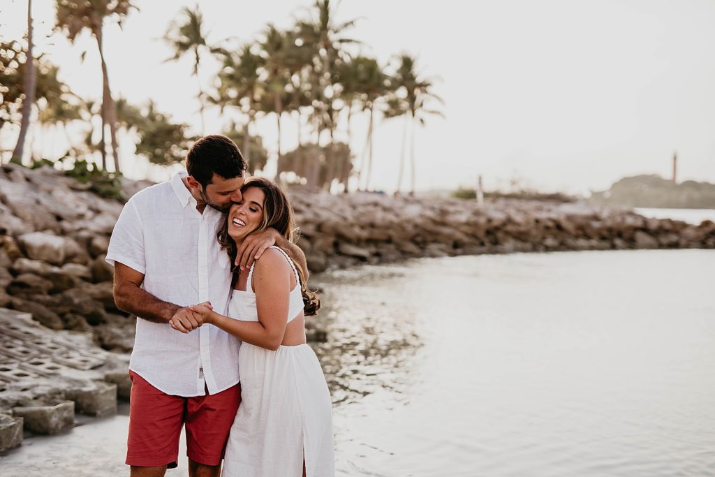 Man kissing woman on the cheek standing in the water