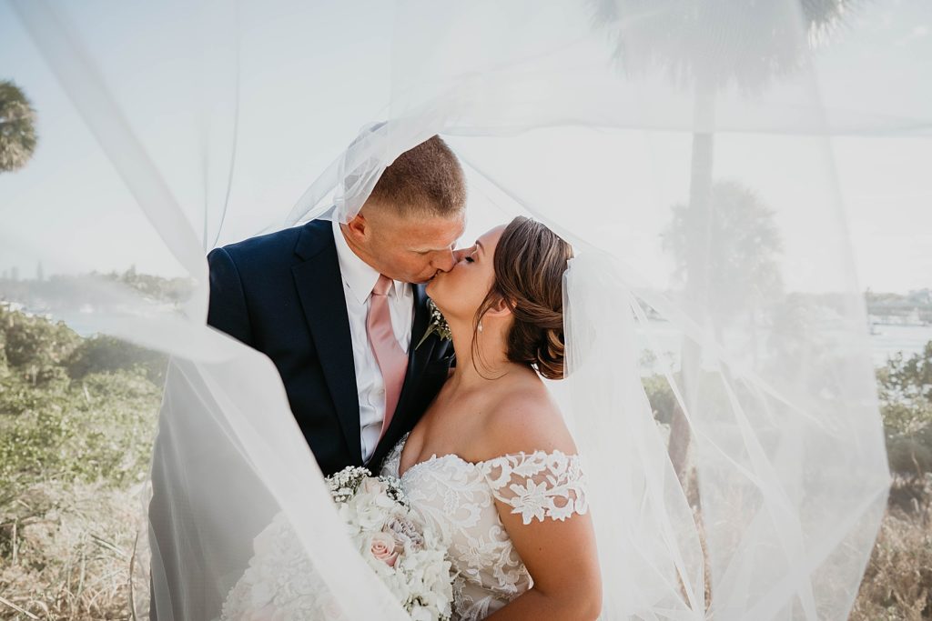 Bride and Groom kissing under veil 