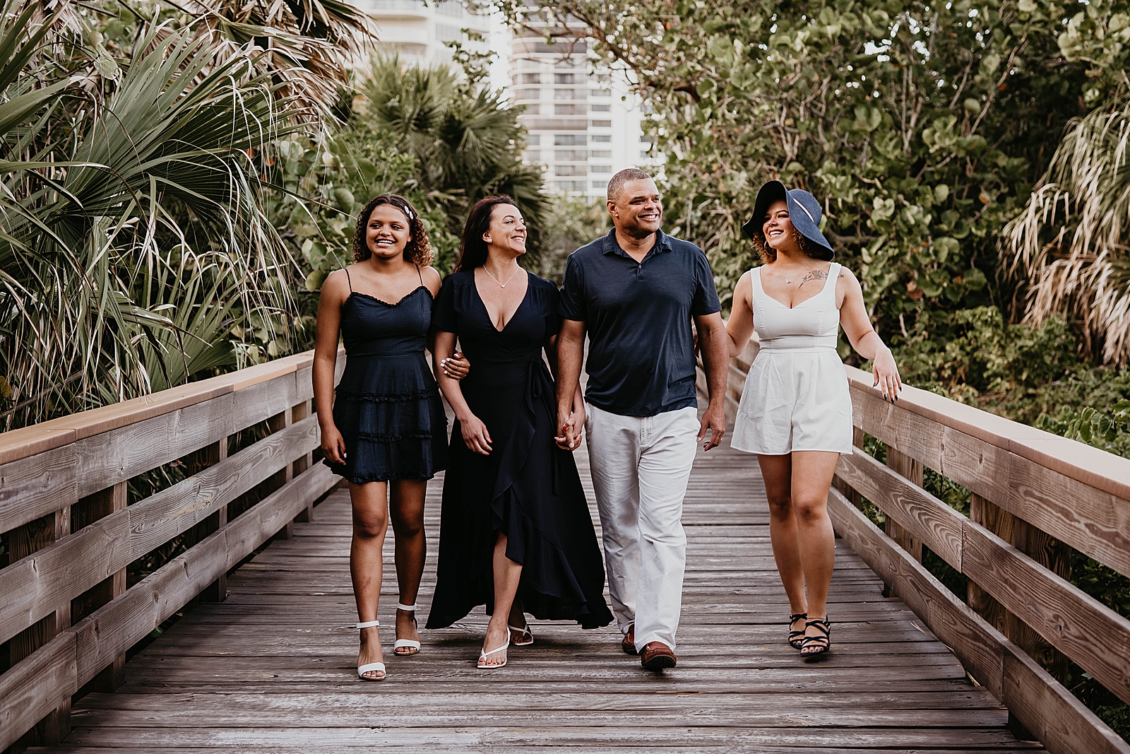 Family arm in arm walking on the bridge together