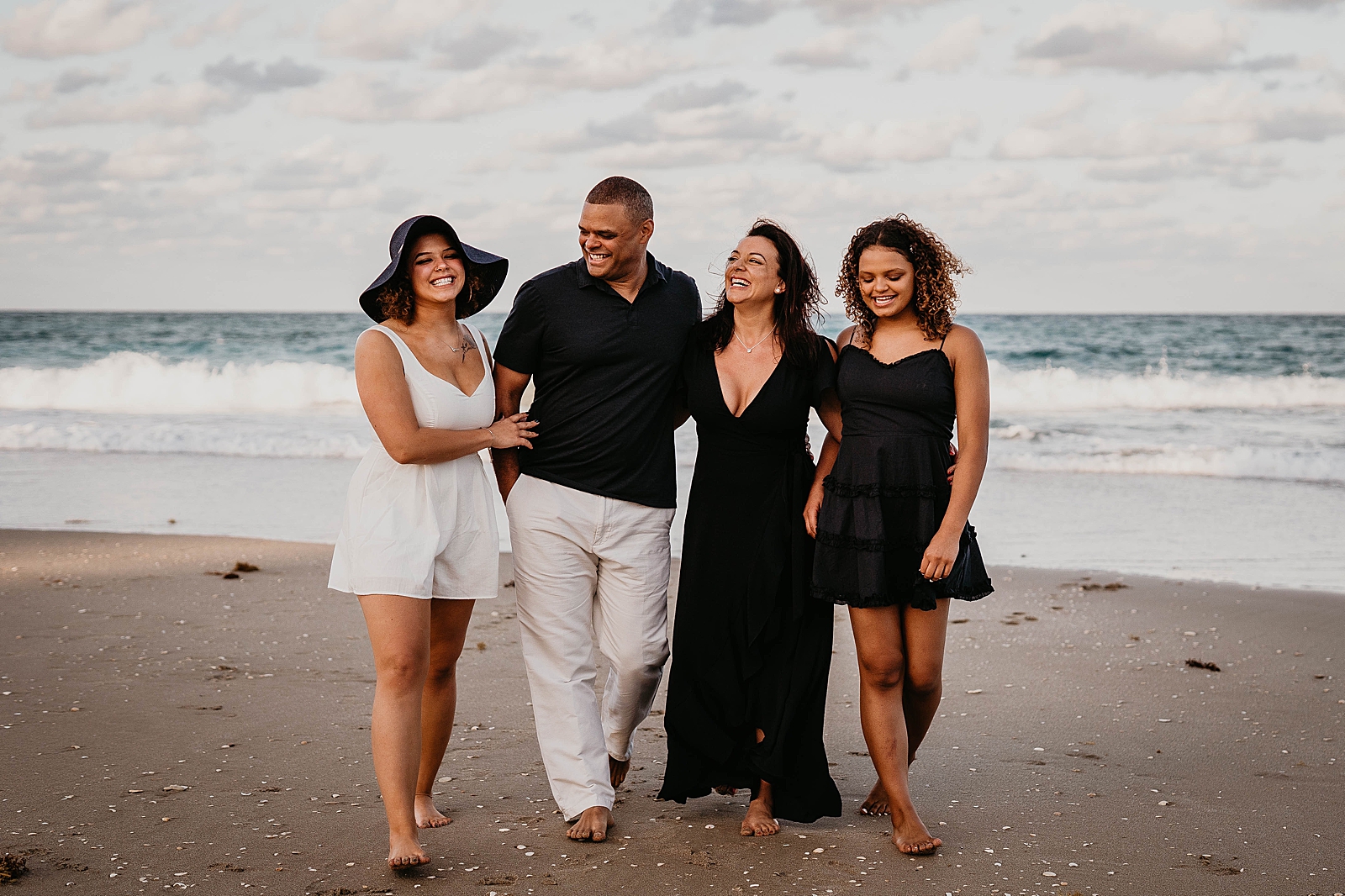 Family walking on the beach with waves crashing behind them