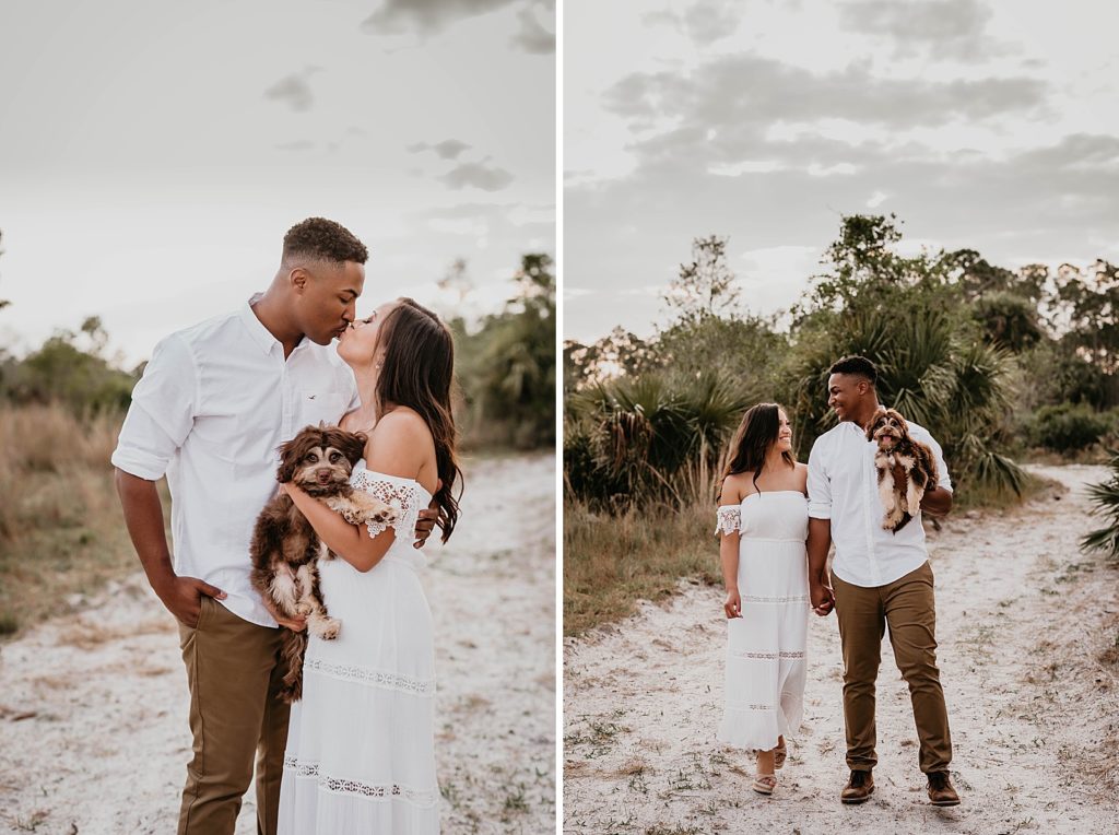 Couple kissing while holding dog