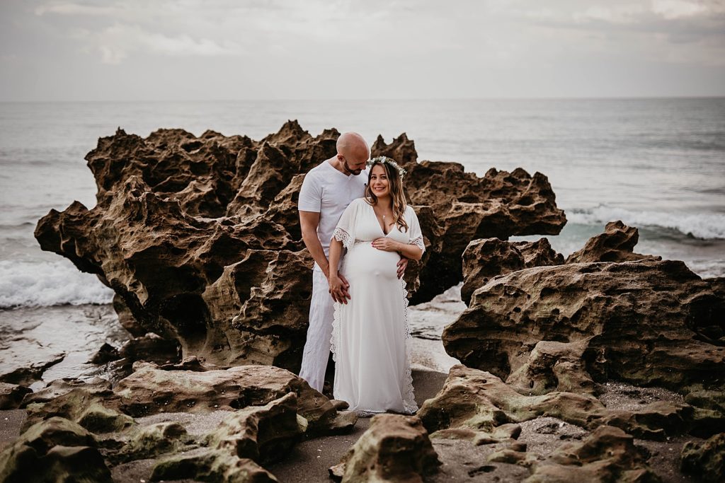 Pregnant couple standing on the drift rock