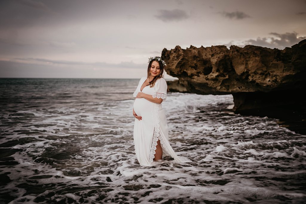 Pregnant woman standing in calm ocean water