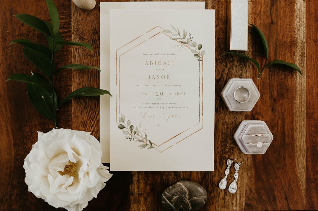 Detail shot of invitation wedding bands and engagement ring