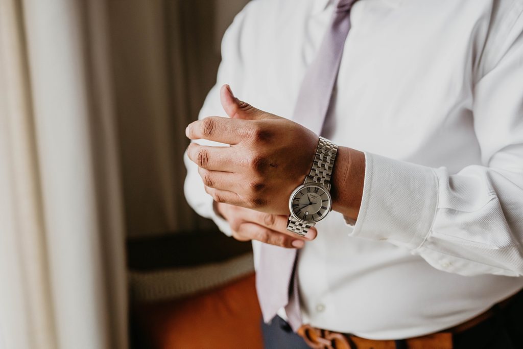 Groom putting on watch closeup
