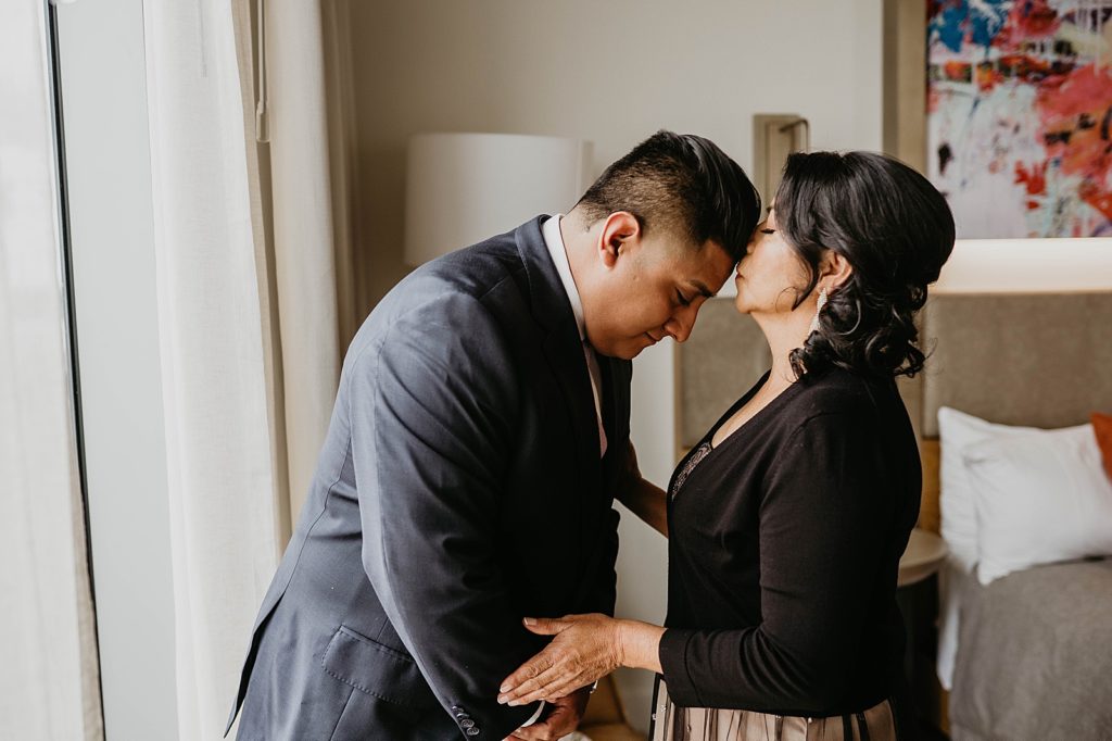 Mother kissing Groom on the forehead