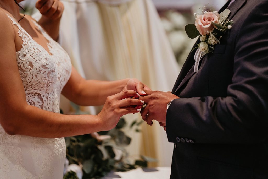 Bride putting ring on Groom