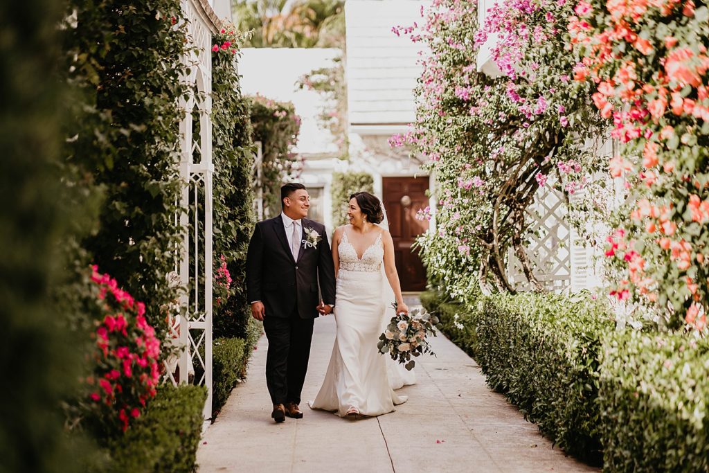 Bride and Groom holding hands and strolling through garden
